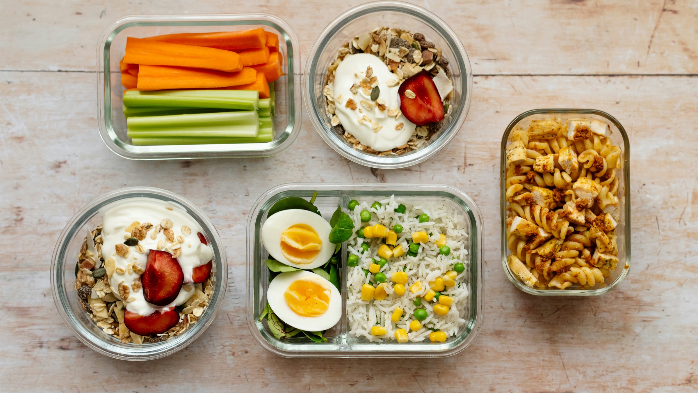 Prepared meals in glass containers on a wooden table
