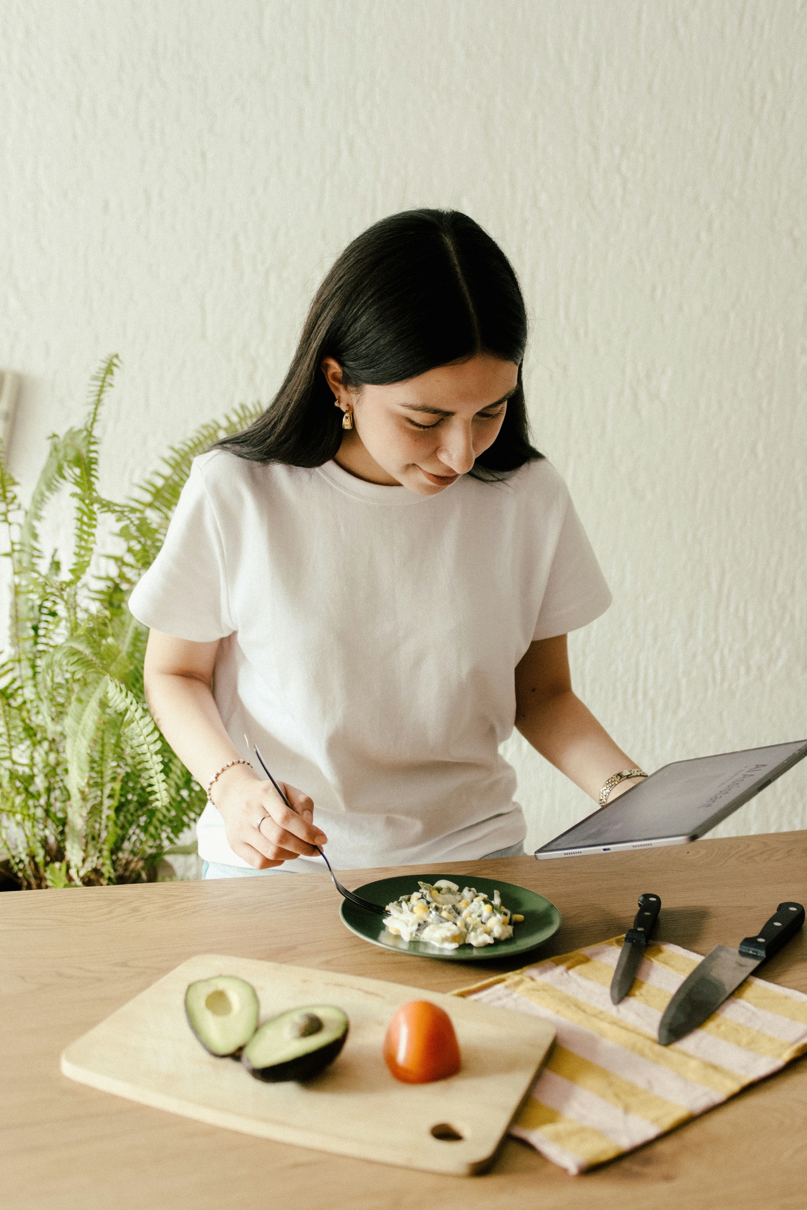 Person reviewing a tablet while eating and recording meal context